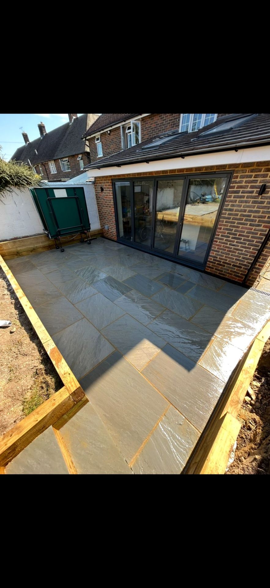 Natural stone patio with timber edging by Burton Builds patio specialists