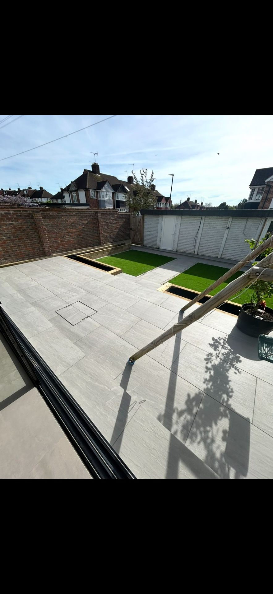 Porcelain paving with grass strip design by Burton Builds landscaping