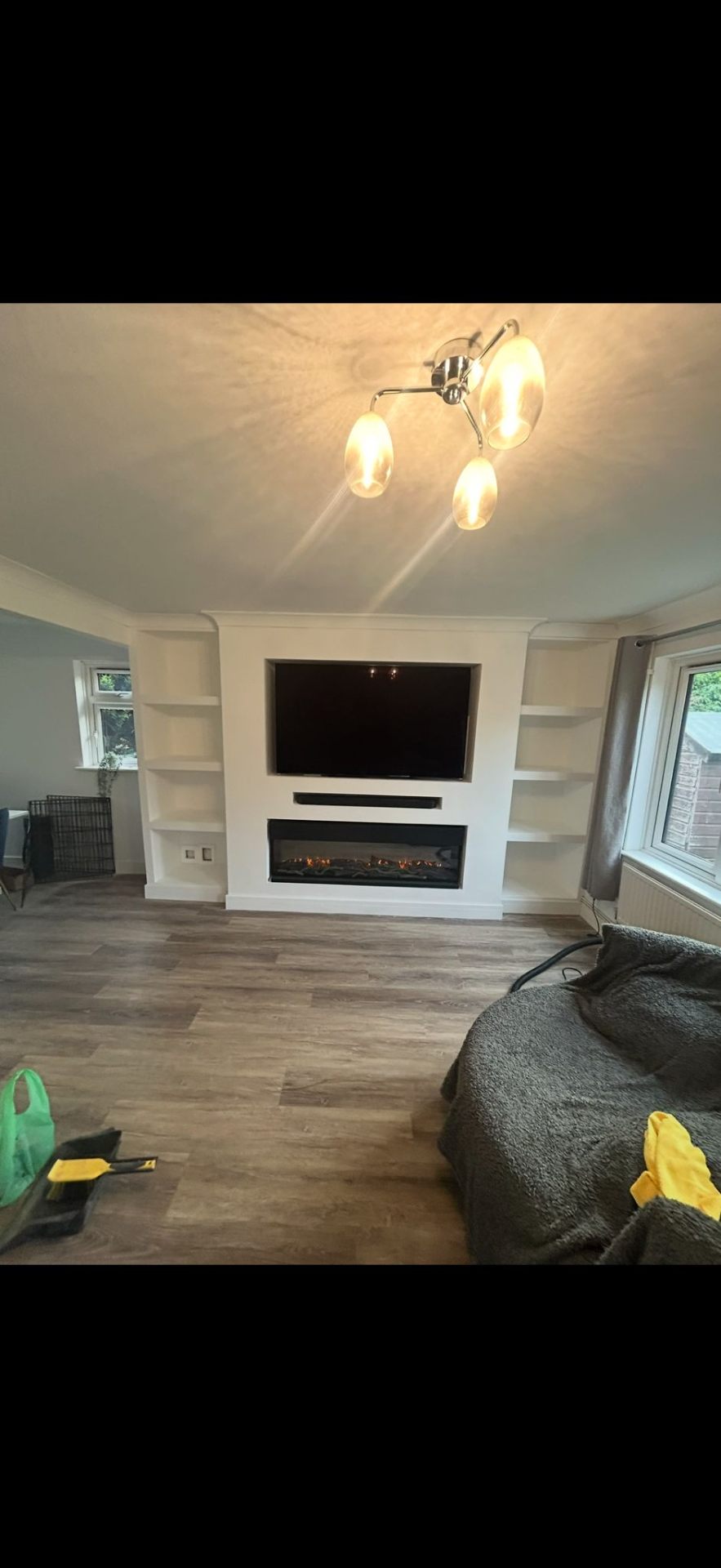 Bespoke media wall with electric fireplace and built-in shelving by Burton Builds