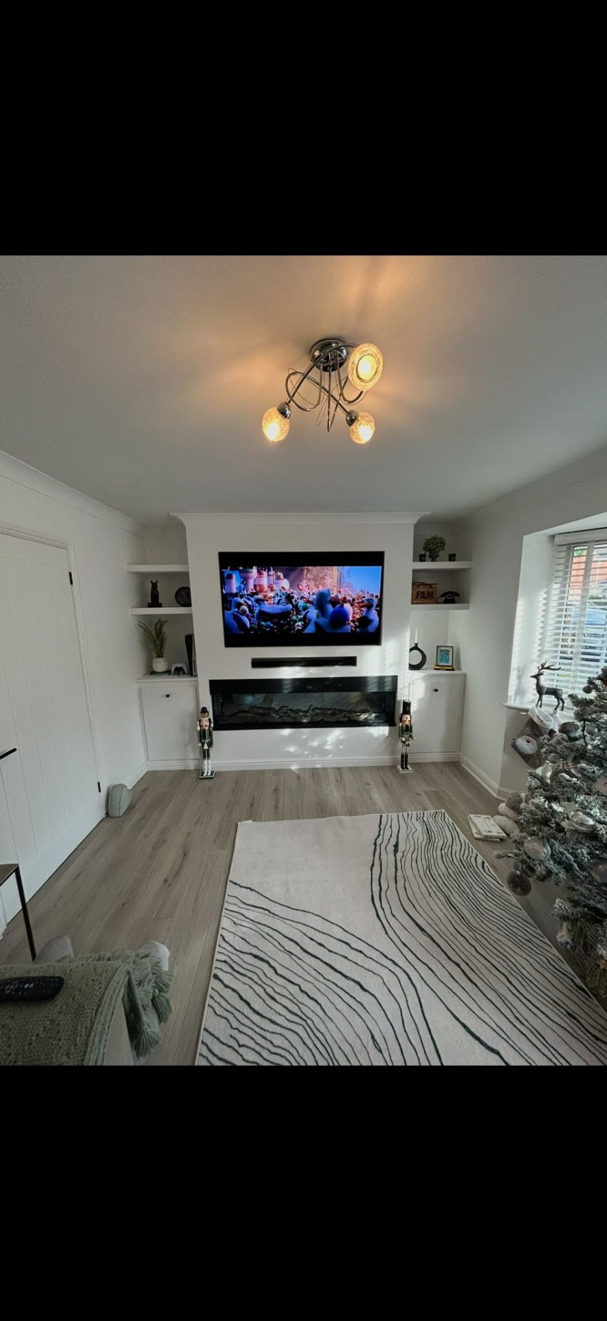 Custom media wall with TV mount and electric fireplace by Burton Builds