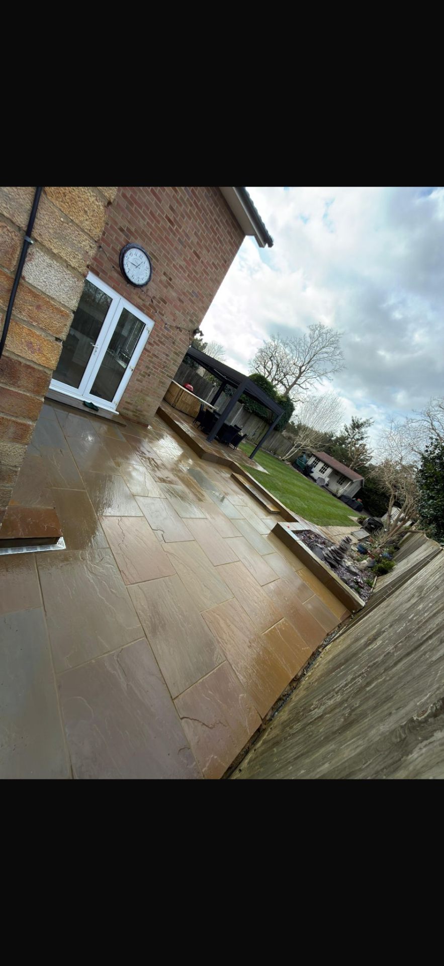 Indian sandstone patio with garden pergola by Burton Builds