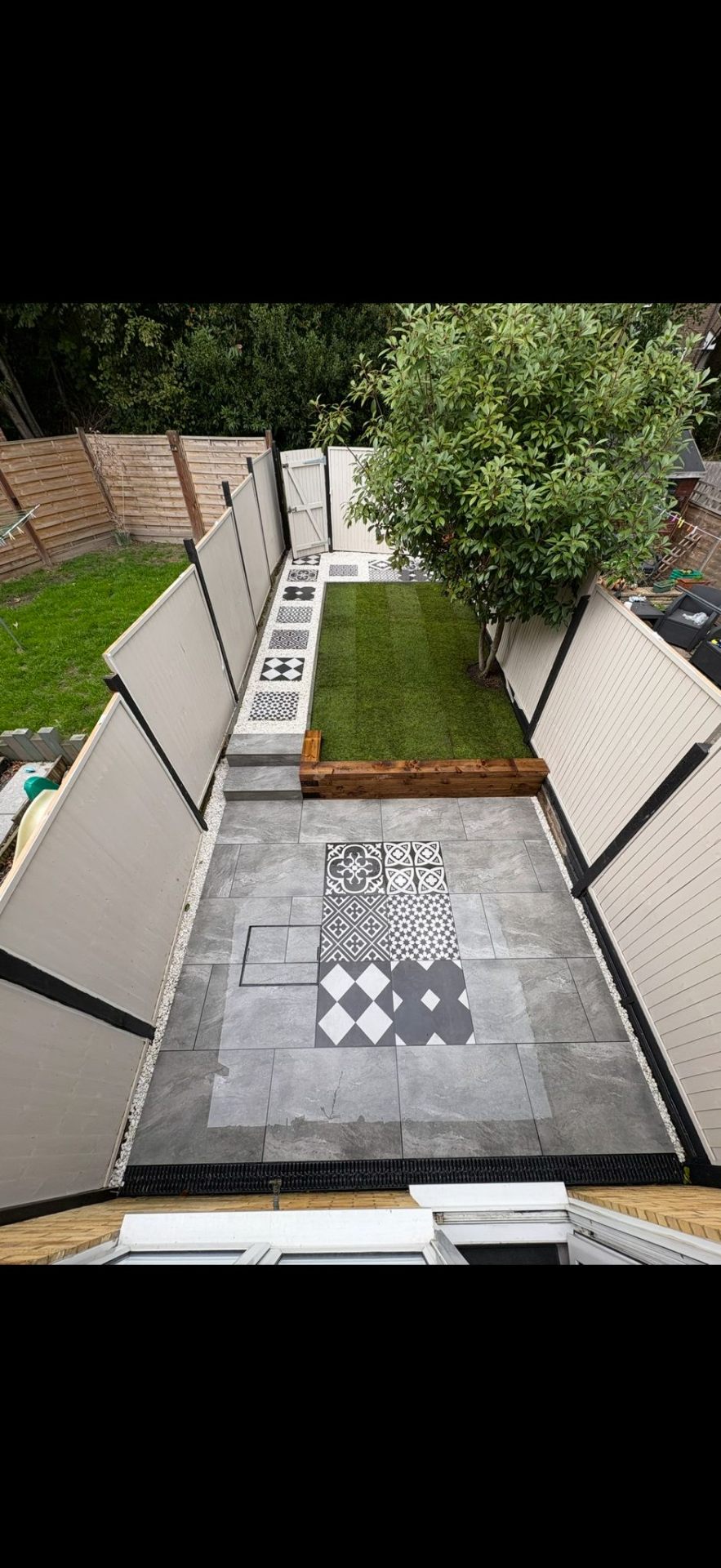 Modern garden with patterned tiles and artificial turf landscaping by Burton Builds