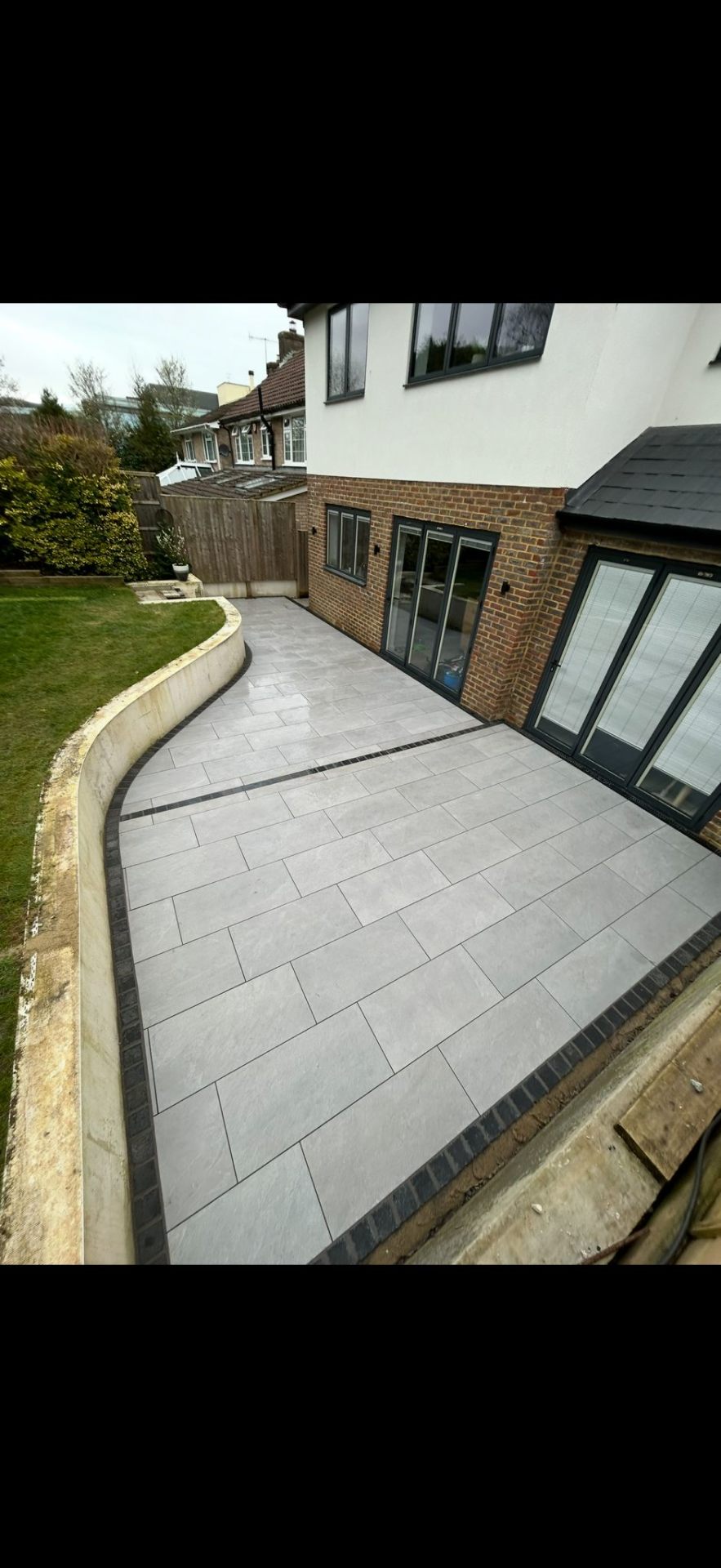 Porcelain patio installation in rear garden by Burton Builds